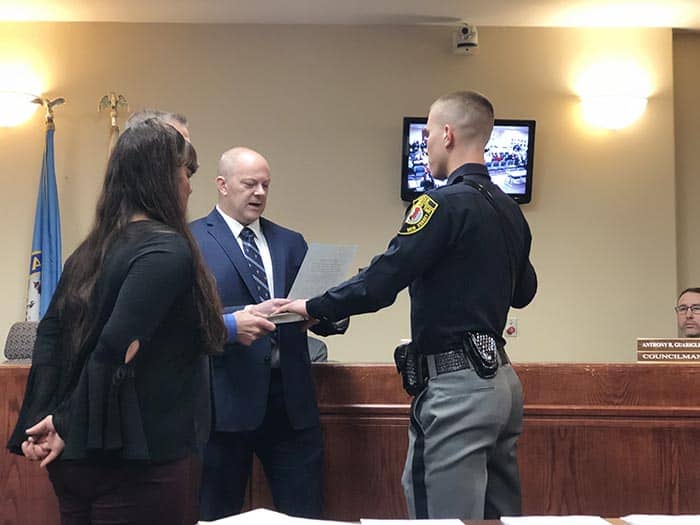 Officer Zach Wiatrowski was sworn in by Mayor Gregory Myhre, surrounded by his parents. (Photo by Kimberly Bosco)