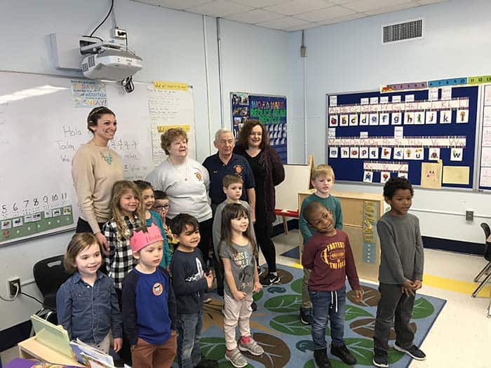 Alyssa Peters’ pre-kindergarten class just sang “The Star Spangled Banner” in honor of their new flag. They are posing with Bob and Darlene Scheiderman and Board of Education member Deborah Pease. (Photo by Chris Lundy)