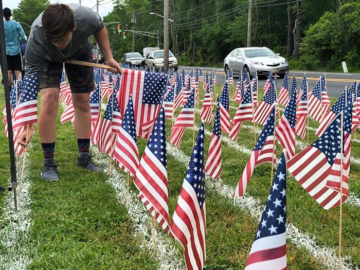 Students plant flags in memory of American soldiers lost in Afghanistan and Iraq. (Photo by Kimberly Bosco)
