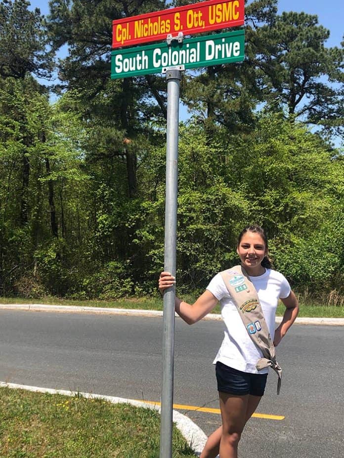 Rory Dunckley stands at a road sign that will soon read “Hawk’s Way.” (Photo courtesy Rory Dunckley)