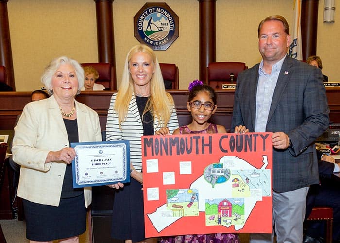 Third place winner Mischa Jain of Indian Hill School (Holmdel) with, from left to right, Surrogate Rosemarie D. Peters, Clerk Christine Giordano Hanlon and Sheriff Shaun Golden. (Photo courtesy Monmouth County)